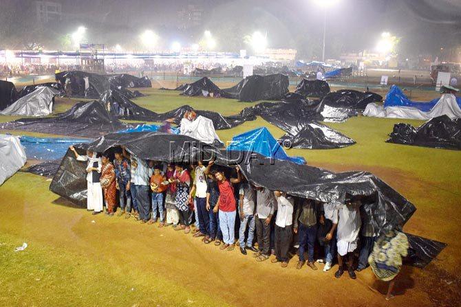 People huddle under plastic sheets at Shivaji Park following the sudden downpour. Pics/ Ashish Rane
