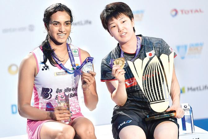 Akane Yamaguchi and PV Sindhu with their respective BWF World Super Series Finals trophies and medals in Dubai yesterday. Pic/AFP
