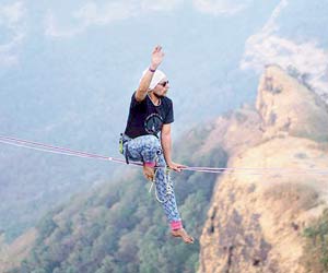 Learn to balance on a flat rope between two cliffs at Lonavla slackline festival
