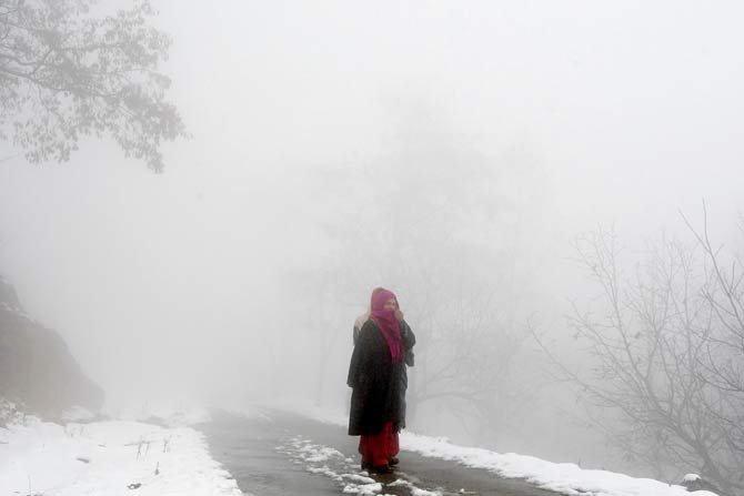 A villager in dense fog after snowfall near Srinagar. Pic/AFP