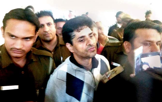 Suhaib Ilyasi being escorted by police at a court in New Delhi on Wednesday. Pic/PTI