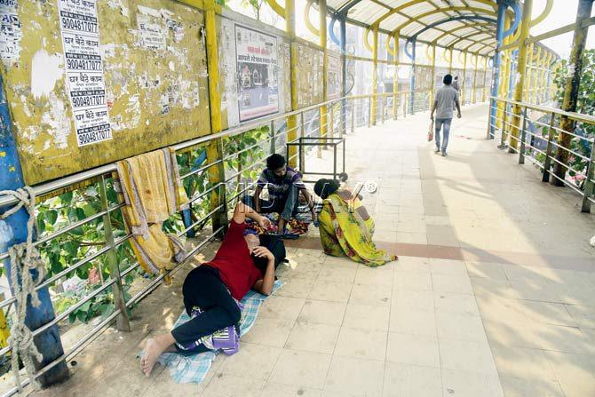 Squatters and hawkers on Thane skywalk cause a lot of inconvenience to pedestrians. Pics/Sameer Markande