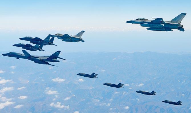 A US Air Force B-1B Lancer bomber (left), two US F-35A and two US F-35B stealth jets (far) flying with South Korea