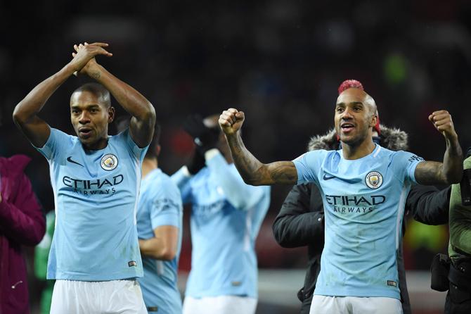 Manchester Citys Brazilian midfielder Fernandinho (L) and Manchester Citys English midfielder Fabian Delph (R) celebrate their 1-2 victory at the end of the English Premier League football match between Manchester United and Manchester City at Old Trafford in Manchester, north west England, on December 10, 2017. Pic/ AFP 