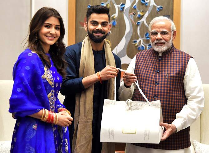 Prime Minister Narendra Modi with newly-wed couple of cricketer Virat Kohli and Anushka Sharma in New Delhi. Pic/AFP