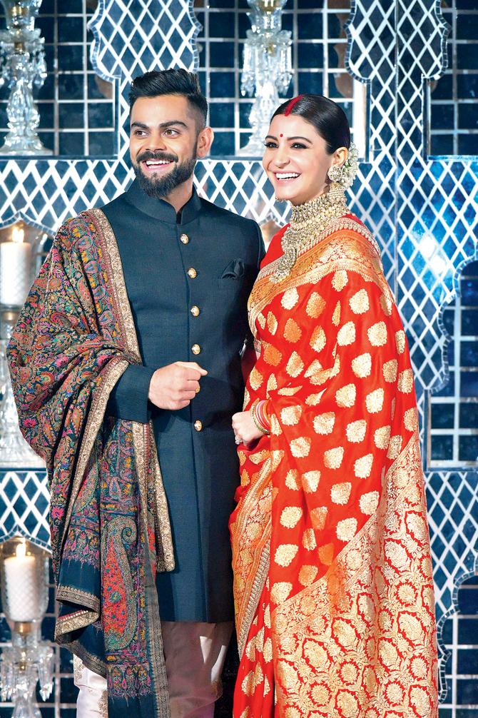 Virat Kohli and his wife Anushka Sharma pose for photographers during their wedding reception