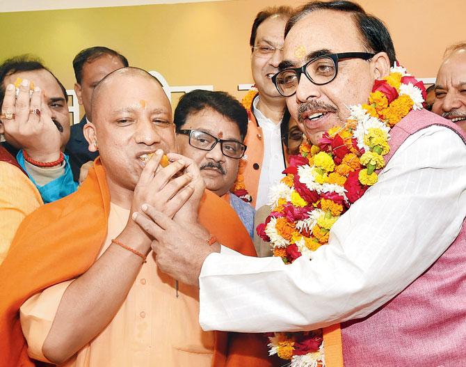 Uttar Pradesh Chief Minister Yogi Adityanath and BJP state president Mahendra Nath Pandey celebrate the victory of the party in the state civic body elections, at the party office in Lucknow, on Friday. Pic/PTI