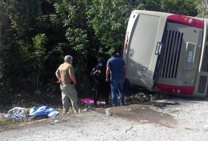 Mexican police officers and paramedics work in the scene of a road accident, where a bus driving tourists to Chacchoben archaeological zone overturned between El Cafetal and Mahahual, in Quintana Roo state, Mexico on December 19, 2017. At least eleven tourists who arrived in the Mexican Caribbean on a US cruise ship were killed and another 20 injured in a road accident on Tuesday when they were heading to an archaeological zone, the Quintana Roo state government reported. Pic/ AFP 