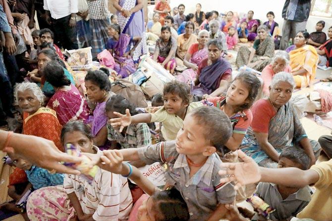 Children receive food and relief material at a TN relief camp