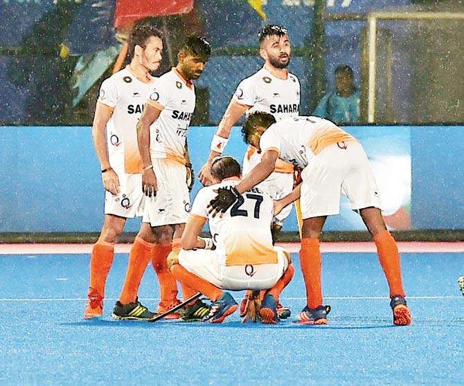 Disappointed Indian players console teammate Akashdeep Singh (on his knees) after their defeat to Argentina in the Hockey World League semi-final at Kalinga Stadium in Bhubaneswar yesterday. Pic/ PTI
