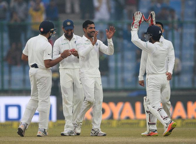 Ravindra Jadeja (C) celebrates with his team mates after he dismissed Sri Lanka batsman Dimuth Karunarathna during the fourth day
