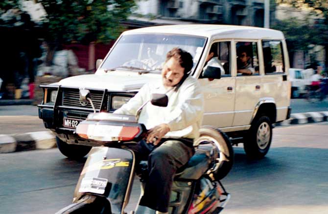 A motorist seen talking on the phone while riding his two-wheeler. Representation pic