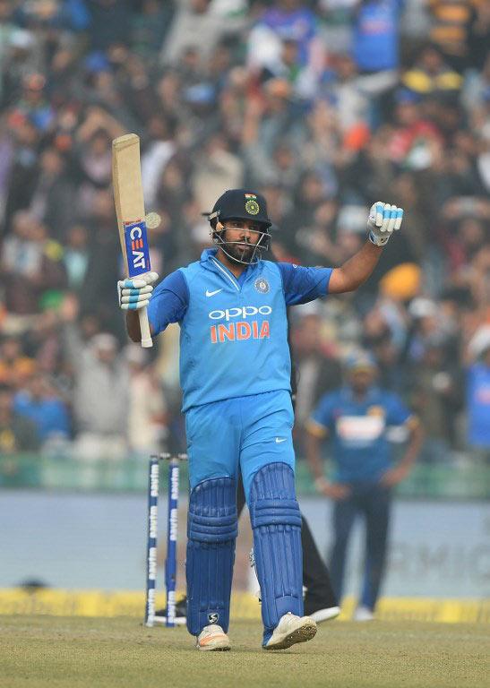 Indian cricket team captain and batsman Rohit Sharma raises his bat after completing his century (100 runs) during the second One Day International (ODI) cricket match between India and Sri Lanka at The Punjab Cricket Association Stadium in Mohali. AFP Photo