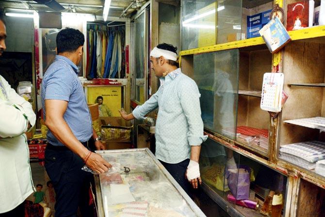 Sunil Mehta shows cops how his shop had been vandalised. Pic/Sneha Kharabe