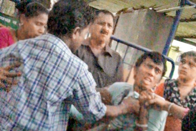 Angel (Ajay) is roughed up by his father outside the police station