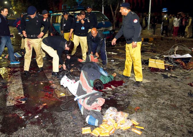 Pakistani police officials move bodies of victims at the site of a bomb explosion in Lahore. Pic/AFP