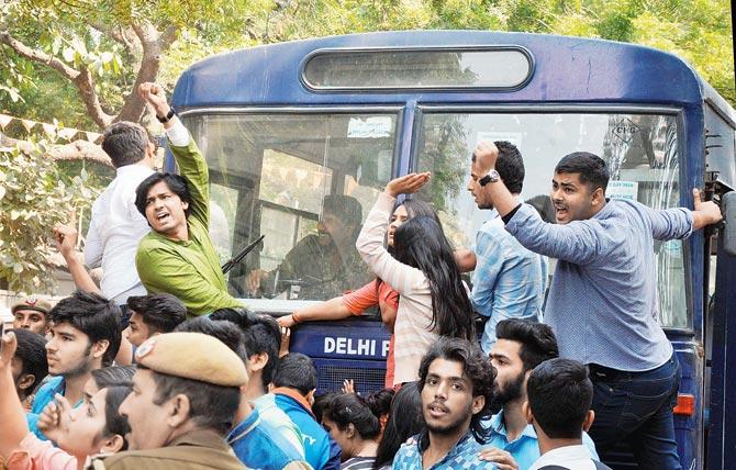 Police detain ABVP activists after their clash with AISA students. Pic/PTI