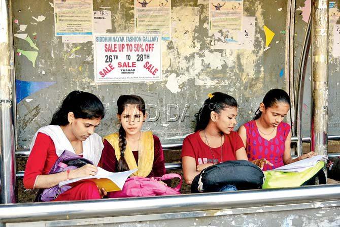 Students pore over their textbooks one last time in a Churchgate-bound train (top) and outside the Ruia College examination centre in Matunga. Pics/ Sameer Markande and Suresh Karkera