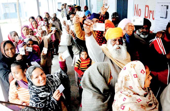 Voters stand in long queues at polling station in Patiala. Pic/PTI