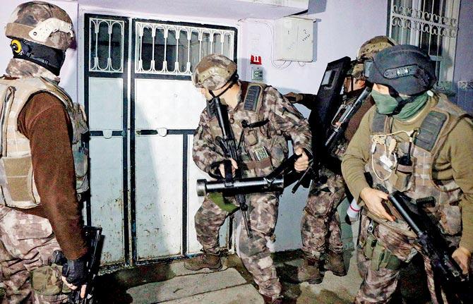 Turkish anti-terrorism police break a door during an operation to arrest people over alleged links to the Islamic State. Pic/AFP