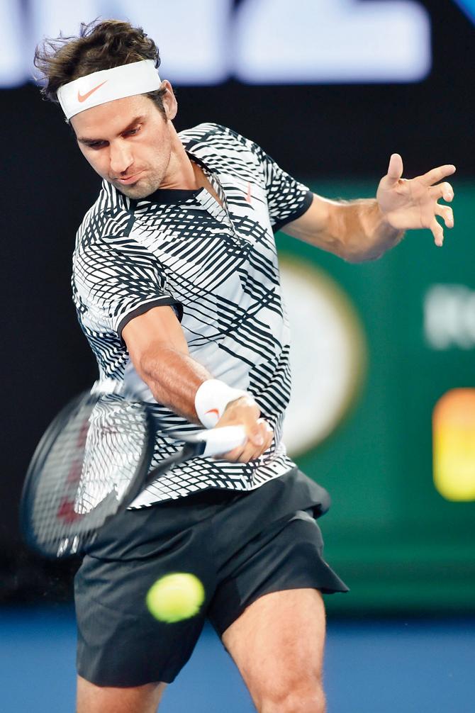 Switzerland’s Roger Federer returns to Austria’s Jurgen Melzer during Day One of the Australian Open at the Rod Laver Arena in Melbourne yesterday. Federer won 7-5, 3-6, 6-2, 6-2. Pic/AFP