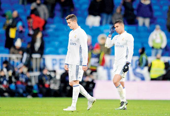 A dejected Cristiano Ronaldo (left) and Casemiro leave the pitch after Real’s 1-2 loss to Celta in a Copa del Rey tie on Wednesday. Pic/Getty Images