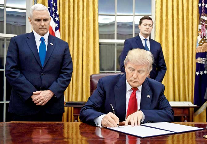 US President Donald Trump signs an executive order as Vice President Mike Pence looks on at the White House on Friday. Pic/AFP