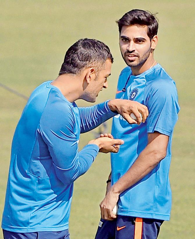 Bhuvneshwar Kumar with MS Dhoni during a practice session in Kolkata on Saturday. Pic/PTI
