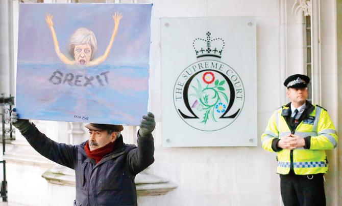 Painter Kaya Mar shows his latest work on British PMâu00c2u0080u00c2u0088Theresa May in front of the Supreme Court in London yesterday. Pic/AP