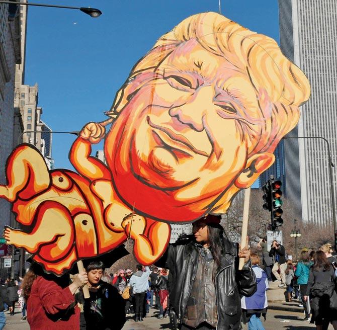 A protester holds up a sign against US President Donald Trump in Chicago. Pic/AFP