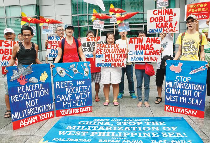Environmental activists in Manila, Philippines, display placards and mock missiles as they picket the Chinese Consulate to protest alleged military build-up by China on South China Sea. Pic/AP