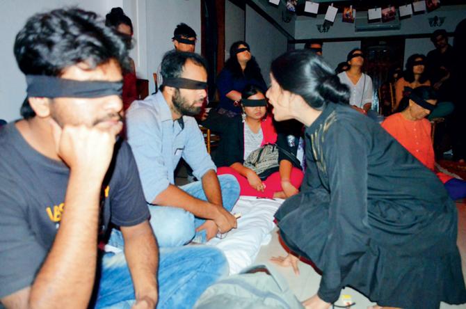 Members of the cast interact with the blindfolded audience at the first edition of the Darkroom Project