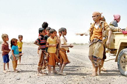 Pro-government fighters distribute food to Yemeni children. Pic/AFP