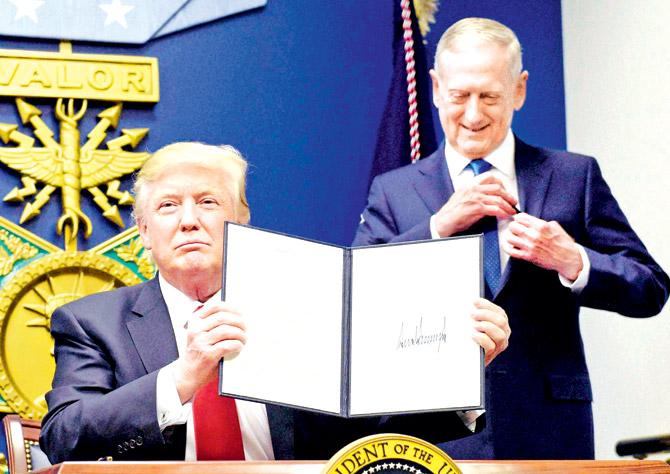 US President Donald Trump holds up an executive action on rebuilding the military after signing it on Friday at the Pentagon. Pic/AP