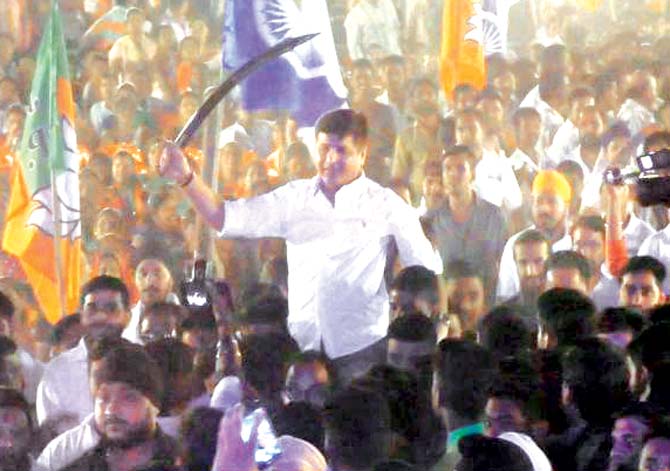 Omi Kalani brandishes a sword as he is carried into the venue on the shoulders of supporters. Pic/Navneet Barhate