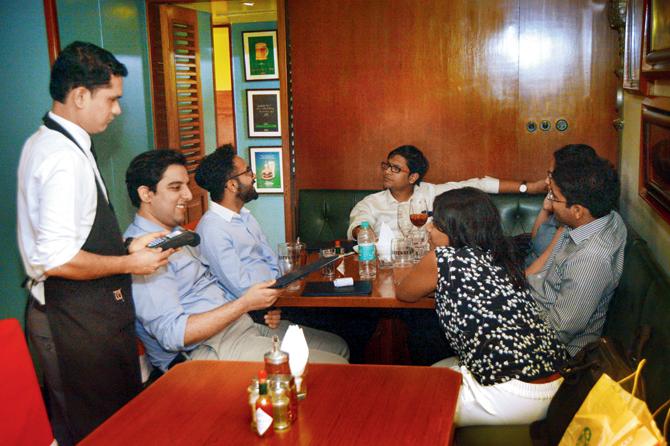 A server gets the swiping machine at a table at Woodside Inn, Colaba. Cash tips have taken a  nose-dive since demonetisation 