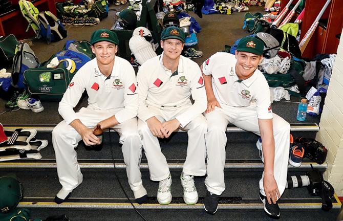 Australian players Peter Handscomb (left), skipper Steve Smith and Matt Renshaw celebrate in the Sydney dressing room on Saturday. Pic/Getty Images