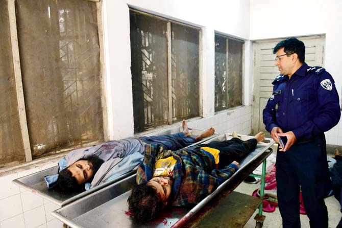A security personel stands alongside the bodies of the terrorists at the Dhaka Medical College. Pic/AFP