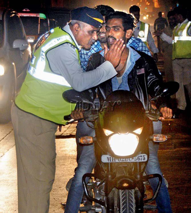A biker blows into a breathalyser for the traffic cops. Pics/Satej Shinde