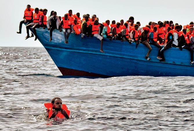 Migrants wait to be rescued in the Mediterranean Sea 20 nautical miles north off the coast of Libya on October 3, 2016. pic/AFP 