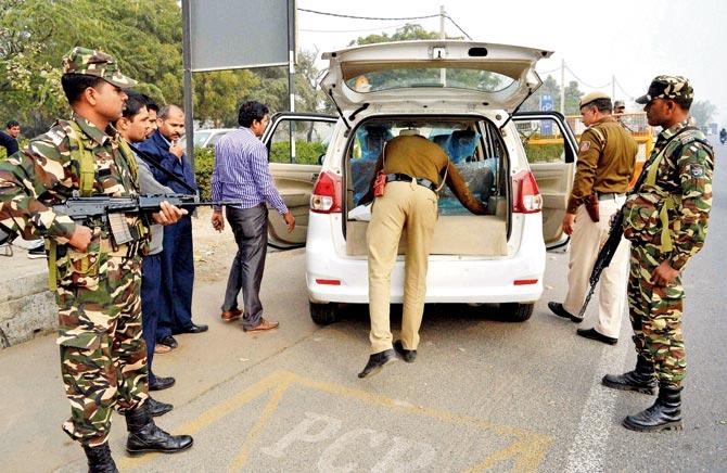 Sashastra Seema Bal and policemen check a vehicle near Delhi-Gurugram border. Pic/PTI