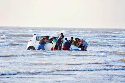 Stranded at seat: Tourists at Alibaug take their cars for a dip