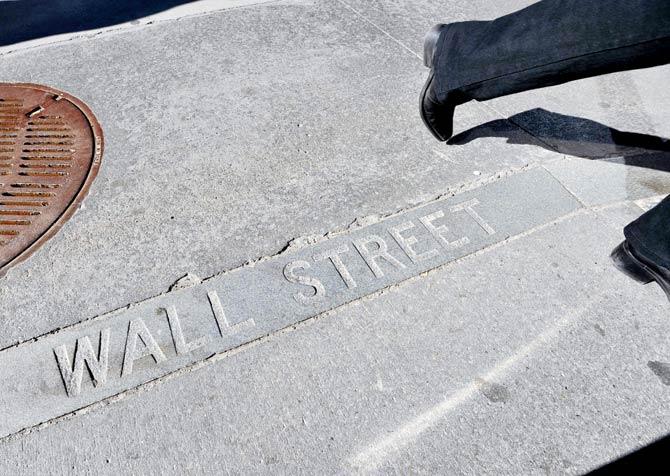 A Wall Street sign on a sidewalk near the New York Stock Exchange. Wall Street opened lower recently, but the Dow Jones Industrial Average remained within shouting distance of the 20,000 mark. Pic/AFP