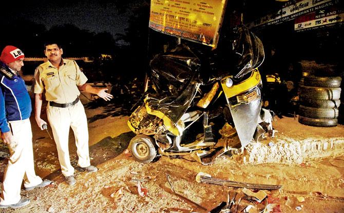 A traffic cop surveys the damage to the car that crashed into a parked autorickshaw (right) on Sion-Panvel Highway last night