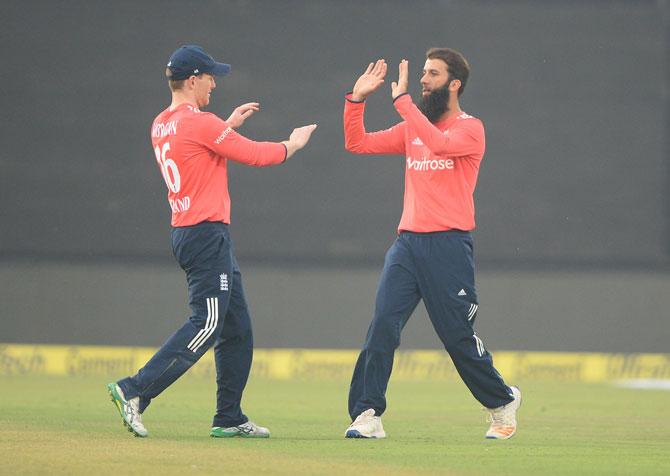 Moeen Ali celebrates with captain Eoin Morgan after dismissing Indian team captain and batsman Virat Kohli during the first T20 cricket match between India and England at Green Park Stadium in Kanpur on Thursday. Pic/AFP