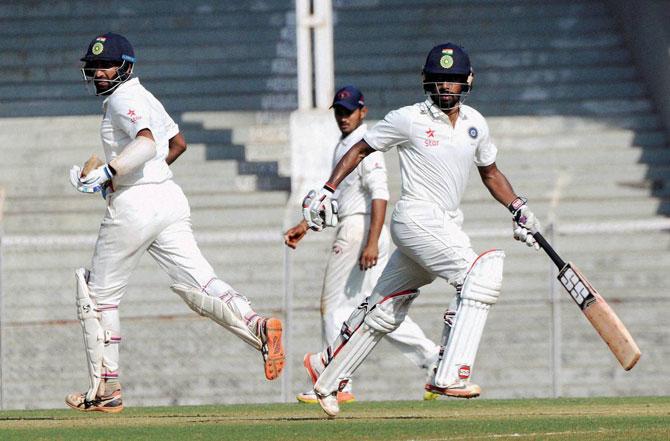 Skipper Cheteshwar Pujara and Vridhiman Saha of Rest India in action during the Irani Trophy match against Gujarat in Mumbai on Monday. PTI 