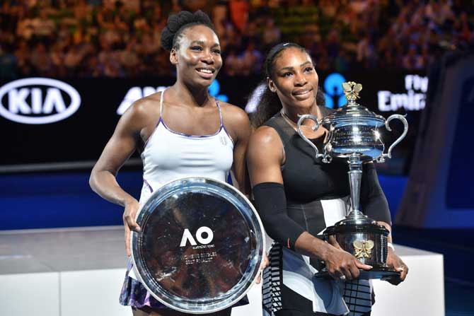 Runner up Venus Williams with winner Serena Williams during the awards ceremony following the women