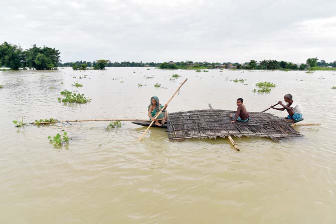 Villagers carry the roof of their house in Balimukh Ashigarh village in Assam. Pic/AFP