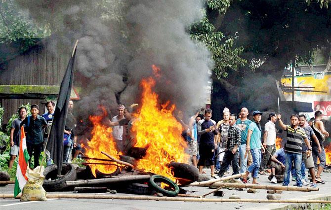 GJM supporters raise slogans after torching vehicles as they clash with police during in Sukna on Saturday. Pic/PTI