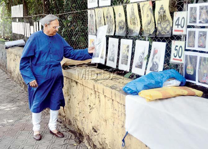 Harsha Dehejia looks at paintings by street artists on the Kala Ghoda stretch leading to Chhatrapati Shivaji Maharaj Vastu Sangrahalaya. Pic/Sayyed Sameer Abedi